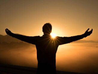 silhouette photo of man on cliff during sunset