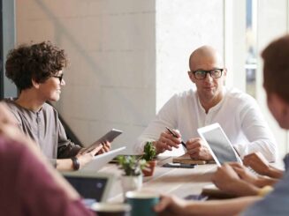 Group of professionals engaged in a brainstorming session around a table in a contemporary office space.